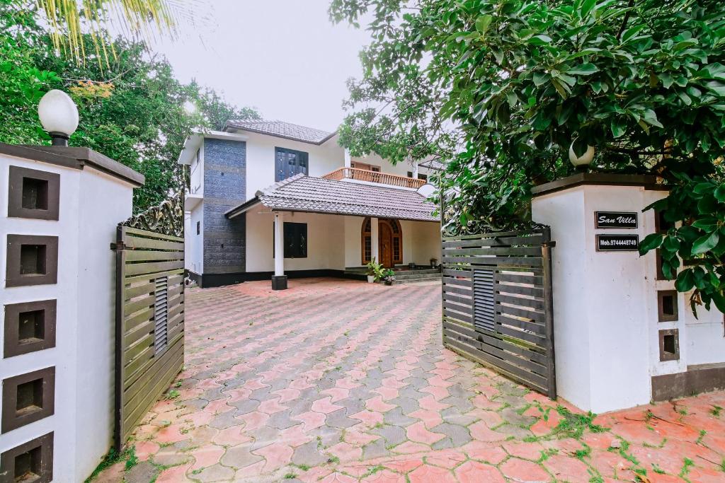 a house with a gate in front of a driveway at San WAYANAD HOMESTAY AND SERVICE VILLA in Sultan Bathery