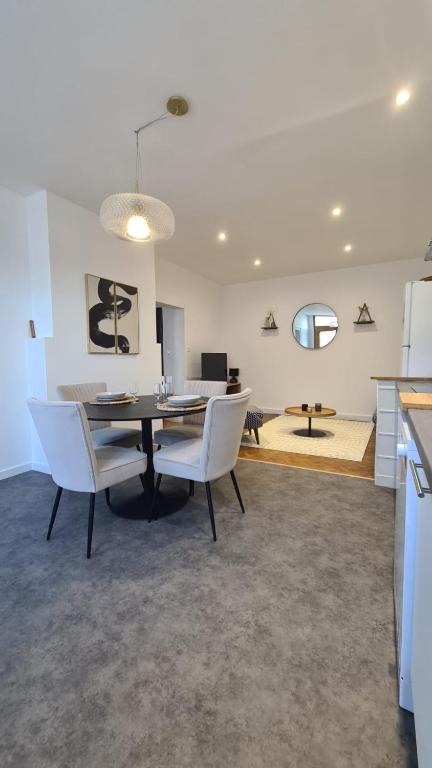 une salle à manger et un salon avec une table et des chaises dans l'établissement Suite Aalto, à Saint-Dizier