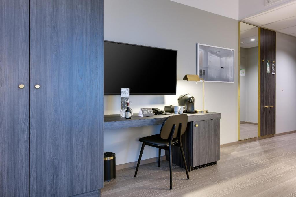 a room with a desk with a chair and a television at Clarion Hotel Air in Sola
