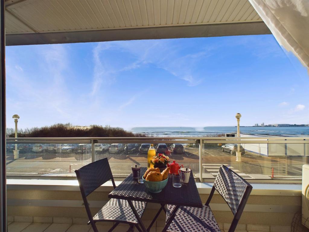 une table avec un bol de fruits sur un balcon dans l'établissement Appartement avec balcon vue mer pour 6 personnes !, à Les Sables-dʼOlonne