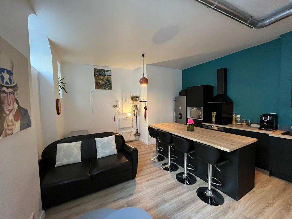 une cuisine avec une table et des chaises dans une pièce dans l'établissement Cosy appartement au coeur des Chartrons et des quais, à Bordeaux