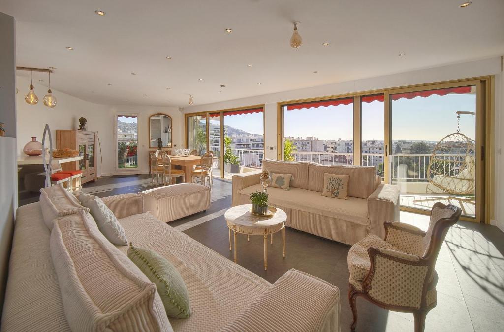 un salon avec un canapé, des chaises et une table dans l'établissement IMMOGROOM -Rooftop 150m2 -Terrace 150m2 -Parking -Wifi - AC, à Cannes