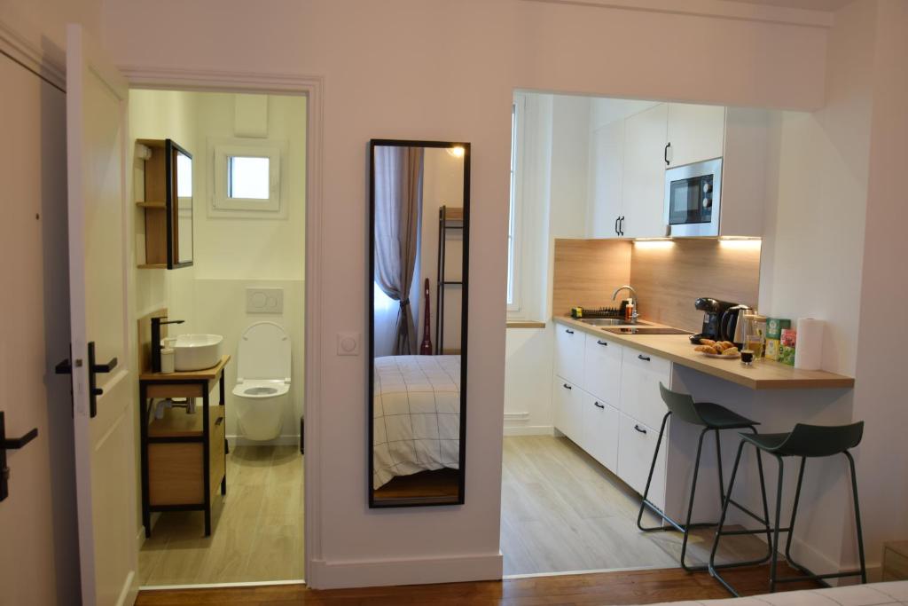 - une petite cuisine avec un évier et un miroir dans l'établissement The Versailles Charm, à Versailles