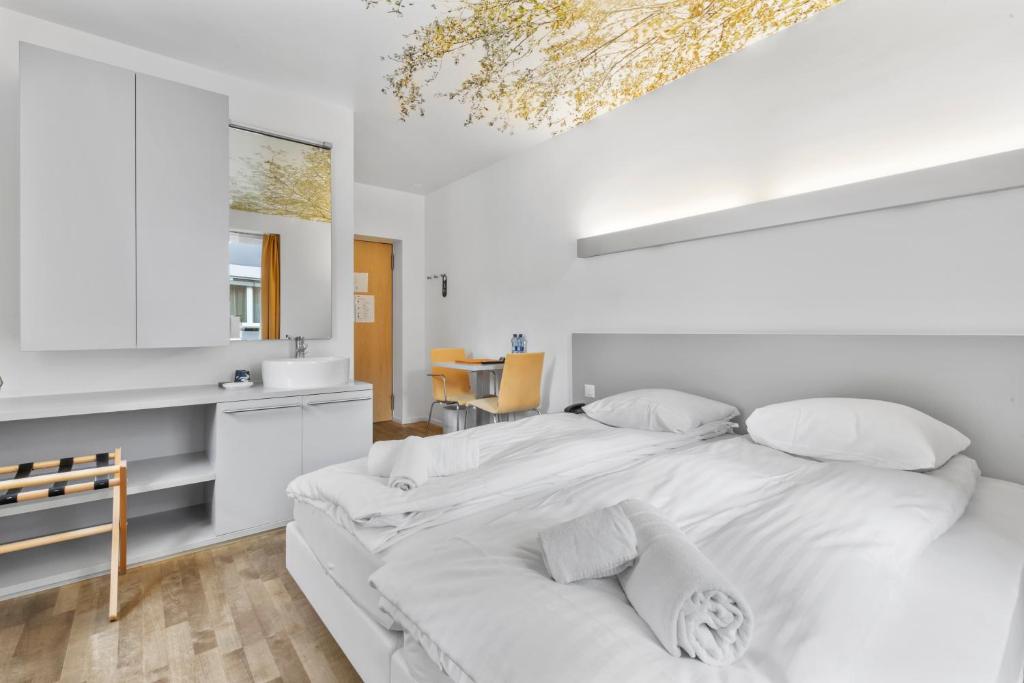 Postel nebo postele na pokoji v ubytování Hôtel de la Poste Sierre