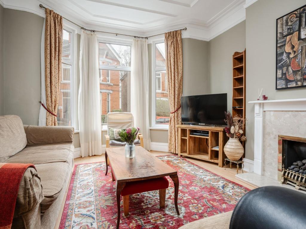 a living room with a couch and a fireplace at Pass the Keys Spacious and Comfortable 3 Bed Home in Birkenhead in Birkenhead