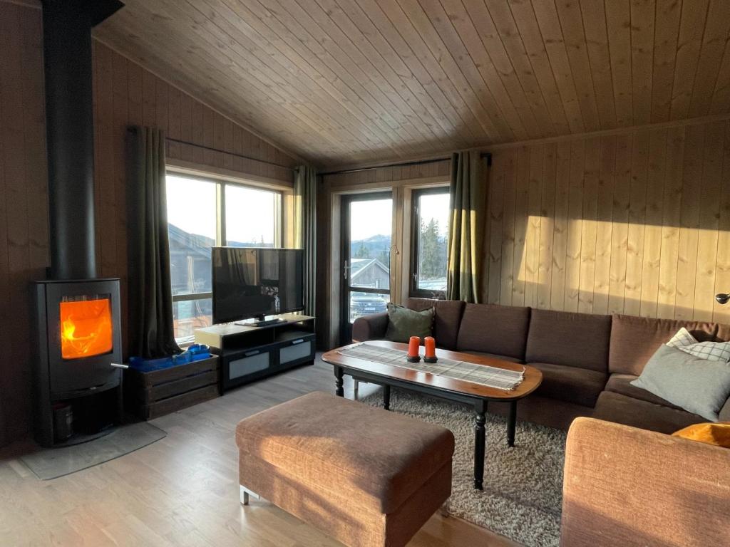 a living room with a couch and a tv at Hjertebo by Norgesbooking - cabin at Spåtind in Nord Torpa