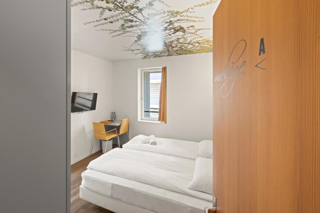 Postel nebo postele na pokoji v ubytování Hôtel de la Poste Sierre
