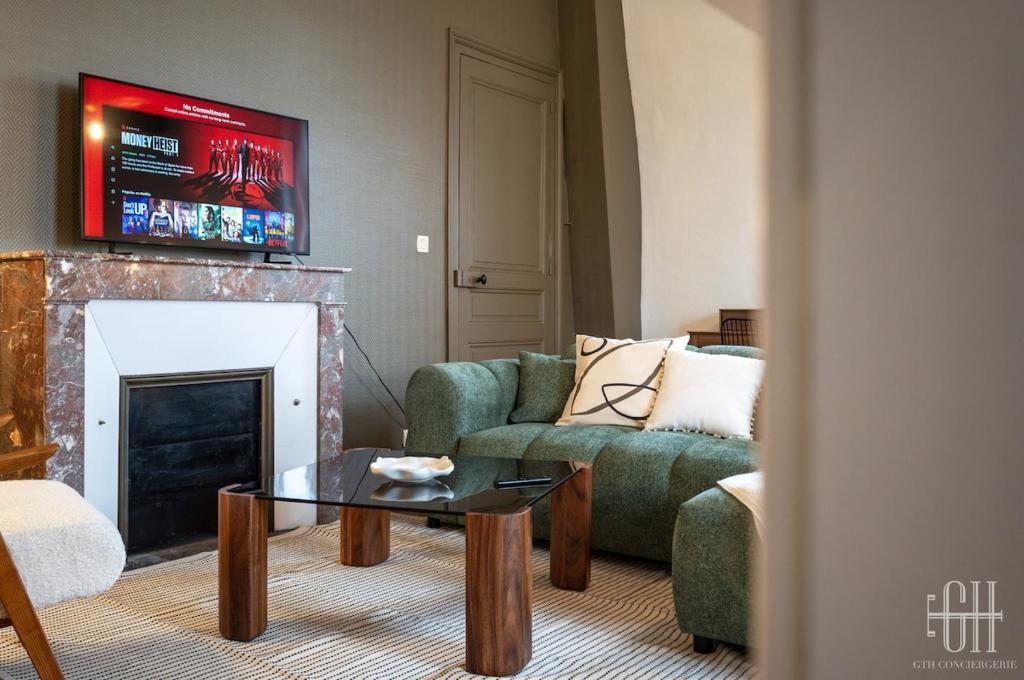 - un salon avec un canapé vert et une cheminée dans l'établissement Appartement avec chambre, parking, bureau, wifi, à Tours
