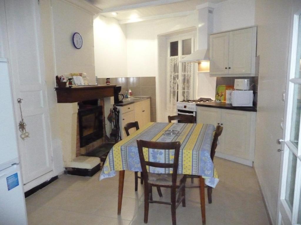 une cuisine avec une table et des chaises et une cuisine avec une cheminée dans l'établissement Europe, à Mortagne-sur-Gironde