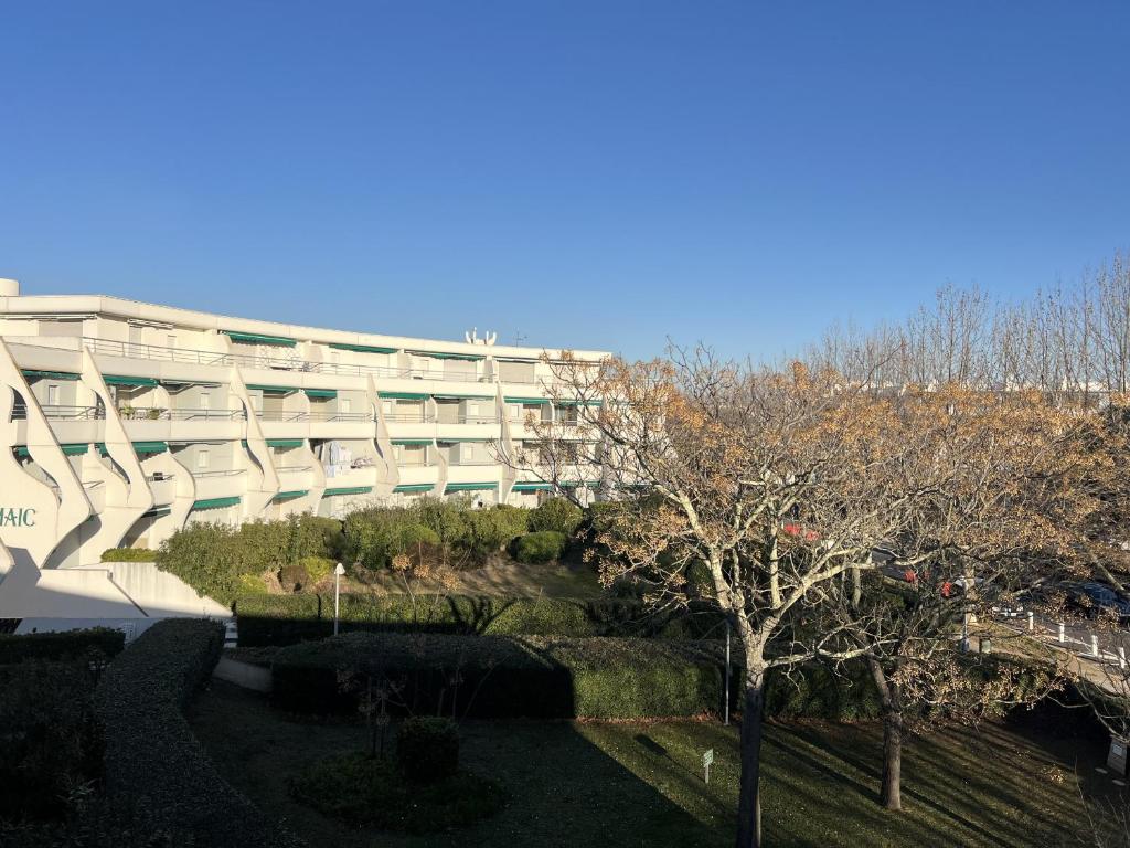 un bâtiment avec un jardin en face dans l'établissement Sol-y-Days Hermes, Charmant studio cabine au calme, à La Grande Motte