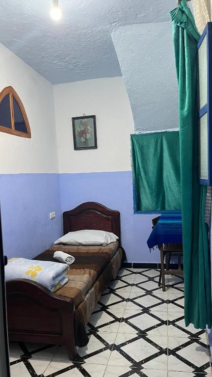 a bedroom with two beds in a room with blue walls at Dar Bleu Pearl in Chefchaouene