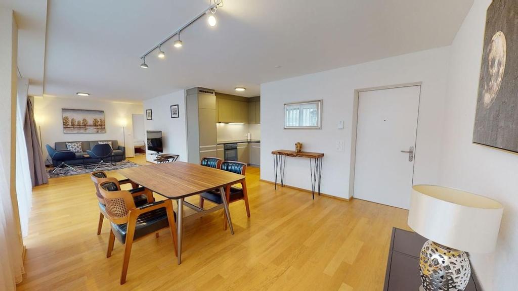 Un comedor y una sala de estar con mesa y sillas. en 2BR flat in the city center - West 12, en Zúrich
