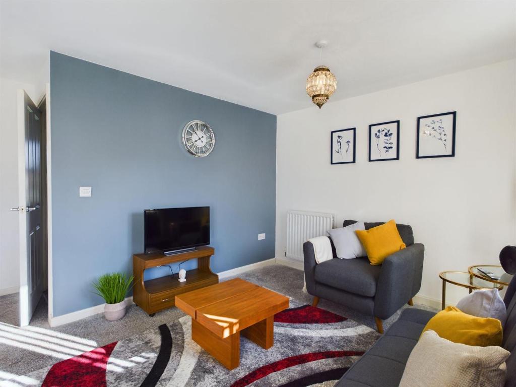 a living room with a couch and a tv at Sleeps6- FamilyFriendly- FreeParking- 3Br in Stafford