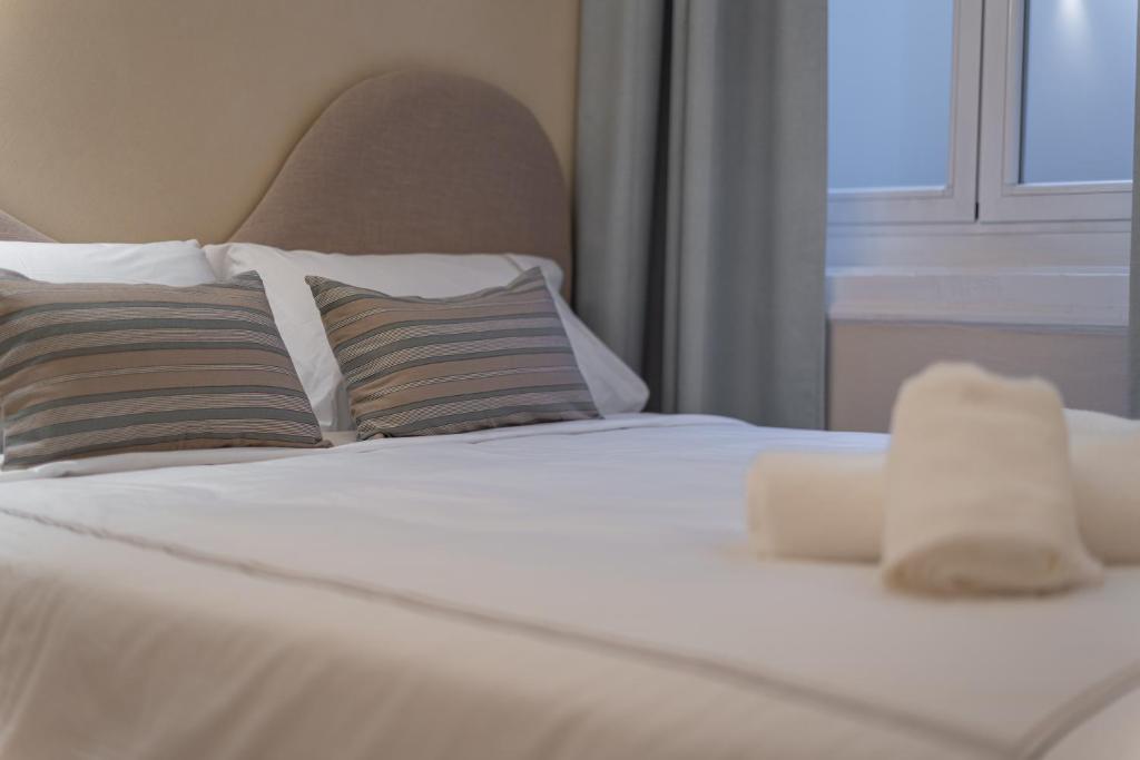 a white bed with two pillows and a window at Das Carretas in Madrid