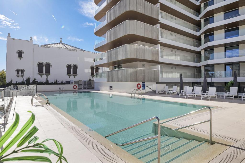 フエンヒロラにあるViVi Homes - Jade Beautiful Apartment with Spa, Pool and Cinema 200 meters from the beachの建物の前のプール