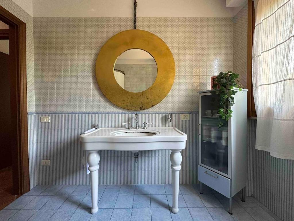 Un baño con un lavabo blanco y un espejo. en Relais Madama Dorè, en Scandicci