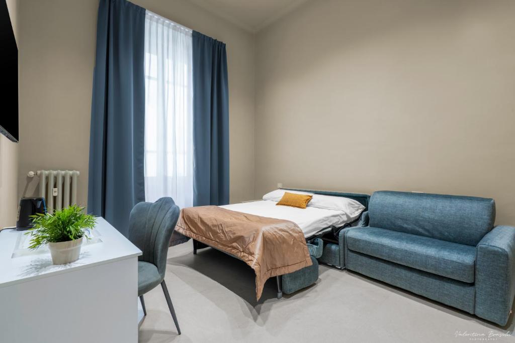 una camera ospedaliera con un letto e un divano di B&B Le Stanze del Duomo a Firenze