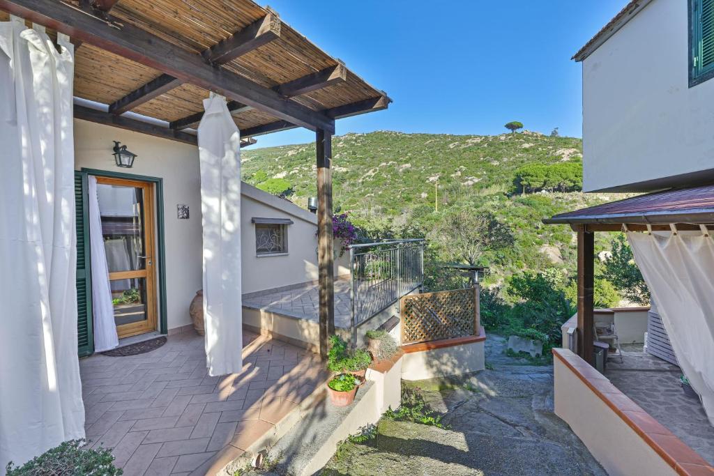 a patio of a house with a wooden pergola at Appartamenti del Sole - Goelba in Seccheto