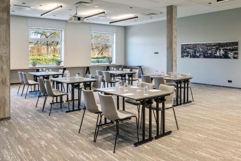a room with tables and chairs and a white wall at Park Inn by Radisson Vilnius Airport Hotel & Conference Centre in Vilnius