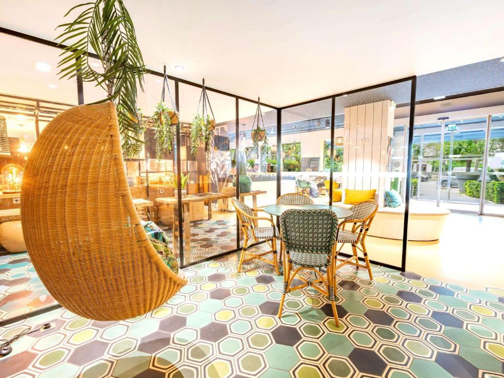a room with a table and chairs and a swing at ibis Styles Paris 16 Boulogne in Paris