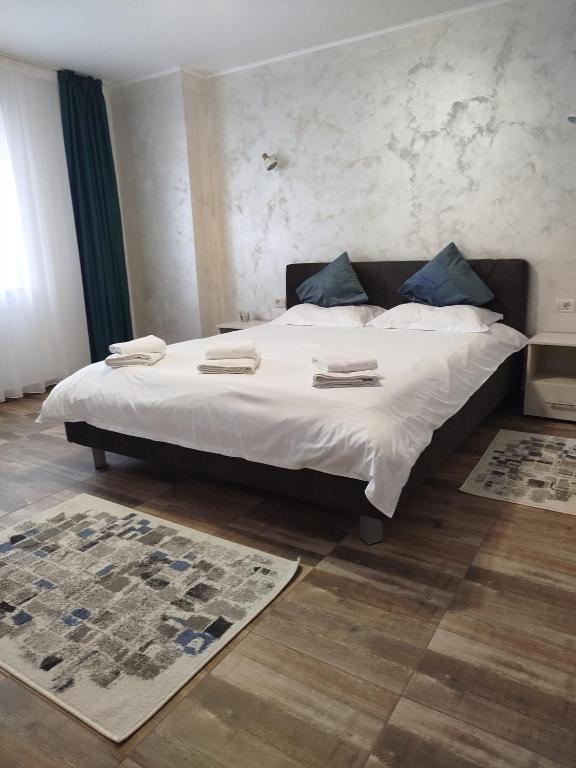 a bedroom with a large white bed with blue pillows at Dimitra in Piatra Neamţ