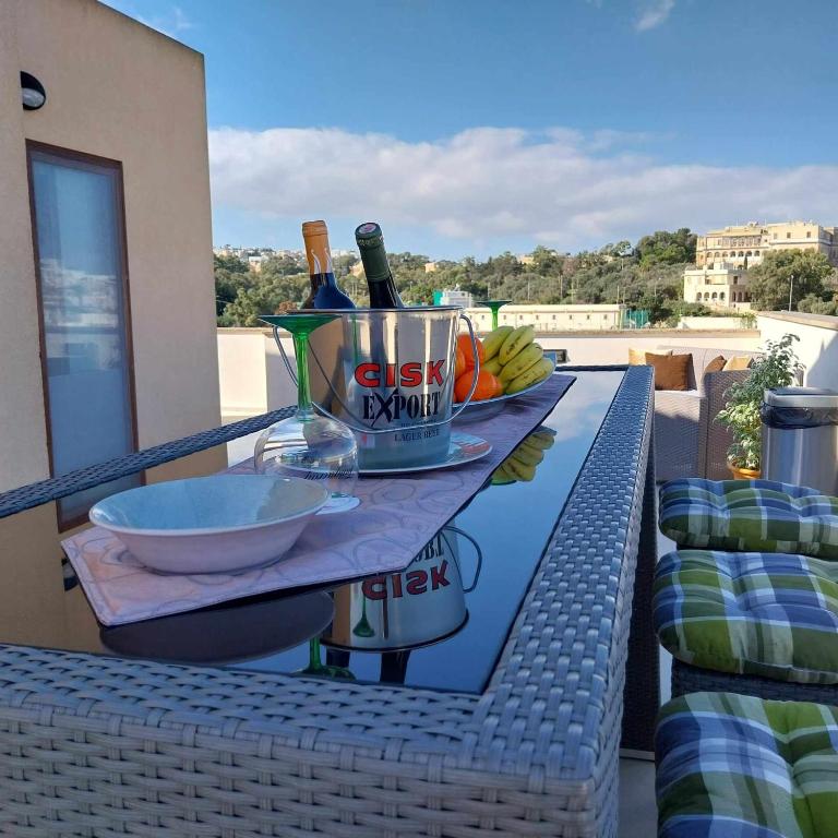 a table with two bottles of wine on a balcony at Luxury 9 person Holiday Home a walk to Paceville's nightlife in Is-Swieqi
