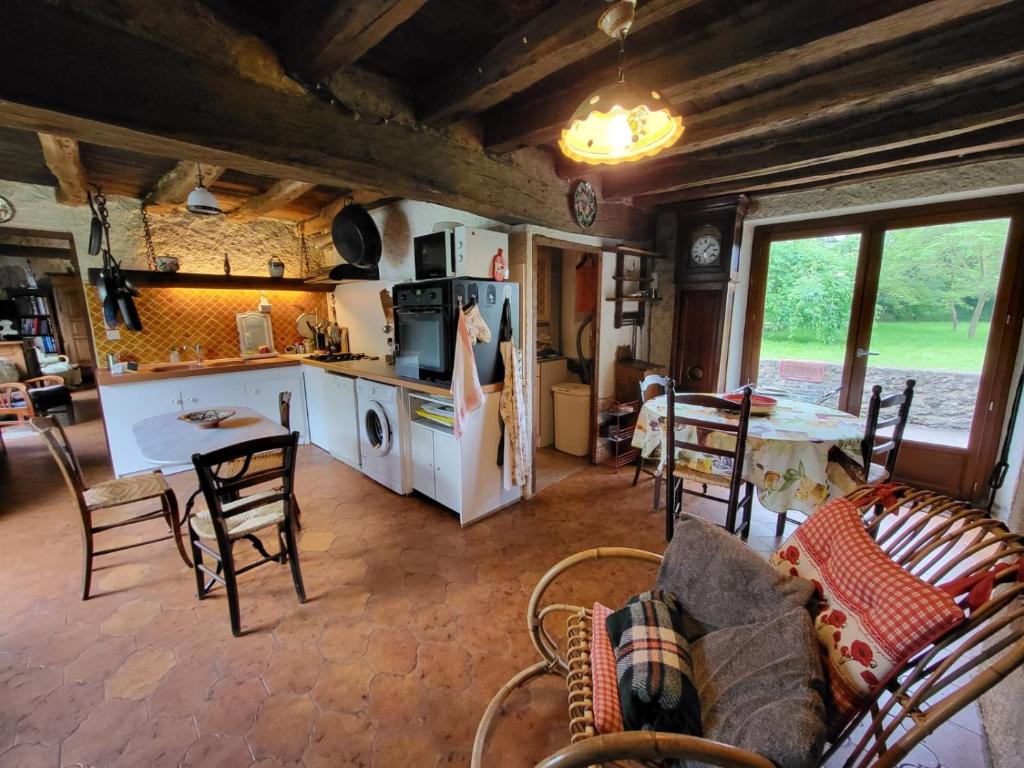 a kitchen and living room with a table and chairs at Maison de Campagne Les Loges de Brenne in Ardentes