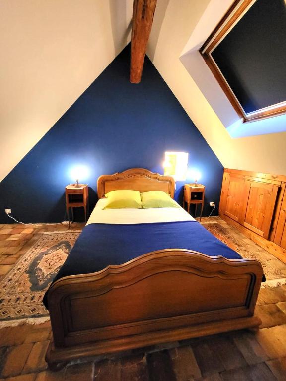 une chambre avec un lit avec un mur bleu dans l'établissement Maison de campagne-jardin-wifi proche Beauval, à Villentrois