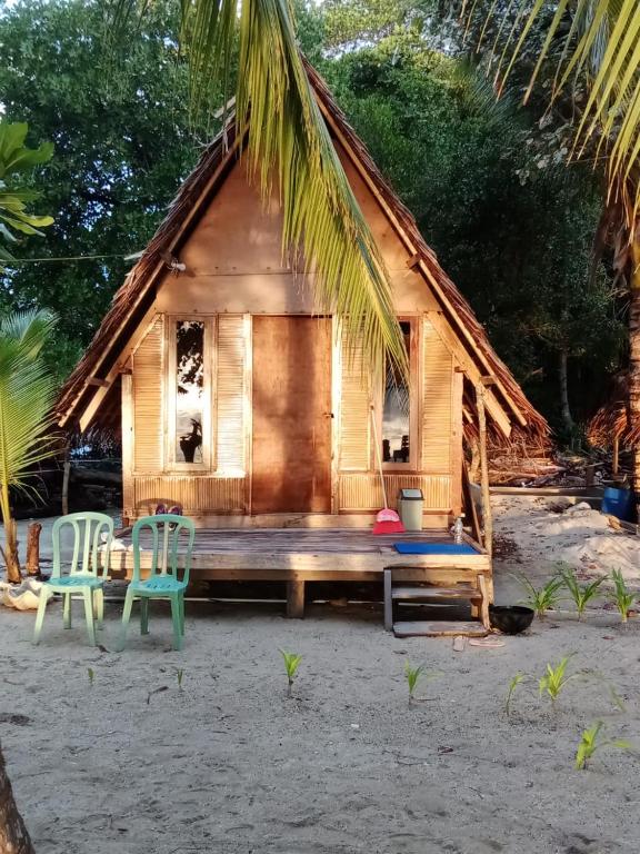 a cabin on the beach with two chairs and a bench at Or Mandira Homestay in Fam