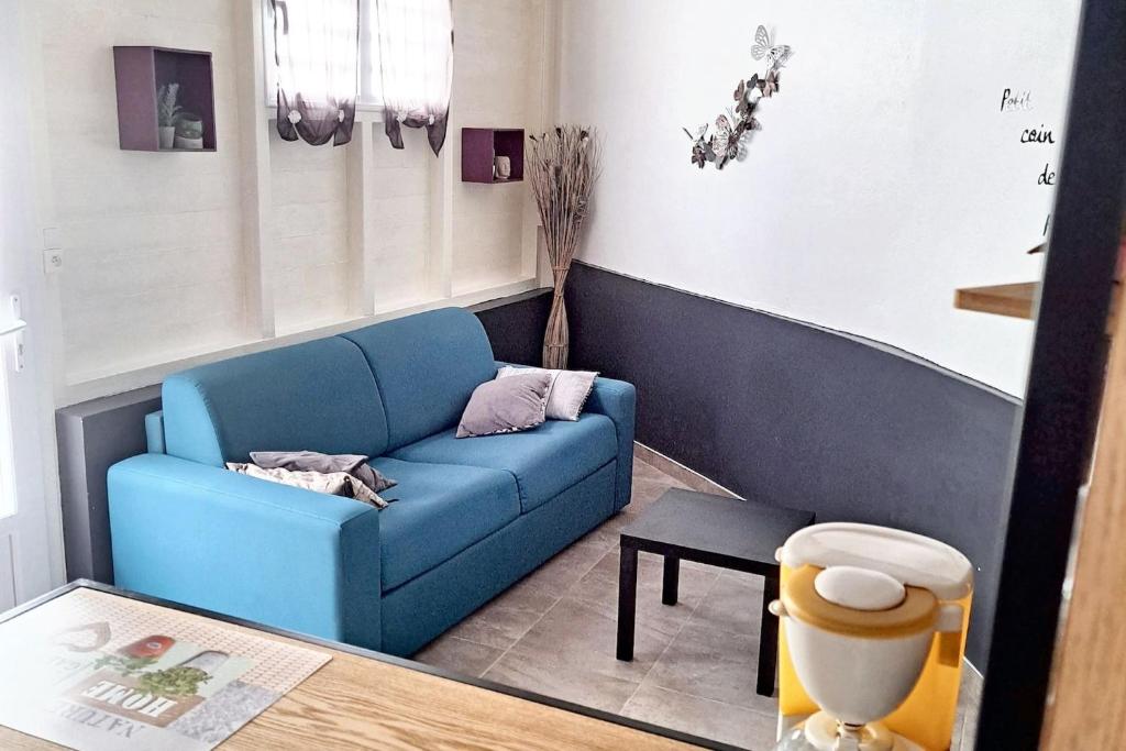 a living room with a blue couch and a table at Studio enchanteur au Diamant avec terrasse privée - 20 m² in Le Diamant