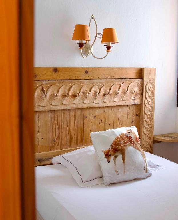 a toy giraffe on a pillow on a bed at Hotel Le Portillo in Val Thorens