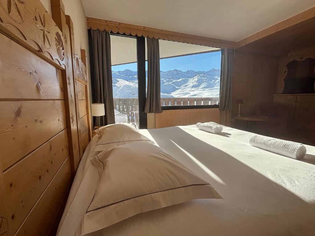 a bedroom with a bed with a view of snow covered mountains at Hotel Le Portillo in Val Thorens