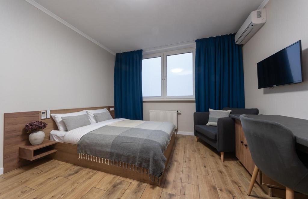 a bedroom with a bed and a chair and a television at N.A.N Apartments on Krushelnytska in Kyiv