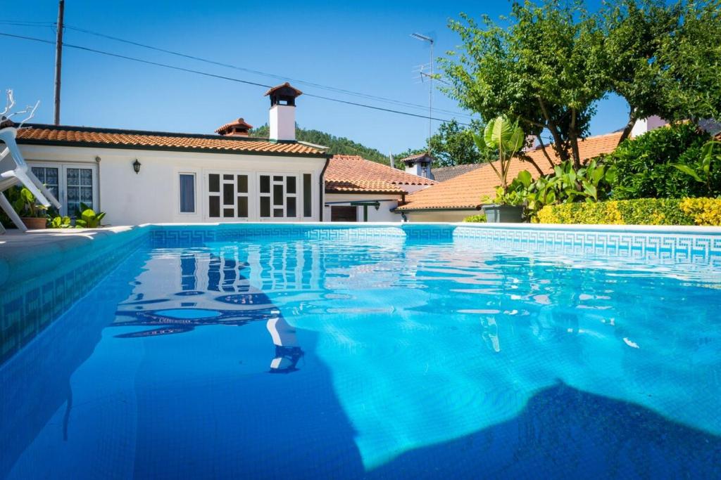 a swimming pool with blue water in front of a house at Casa de Alvite in Alvito