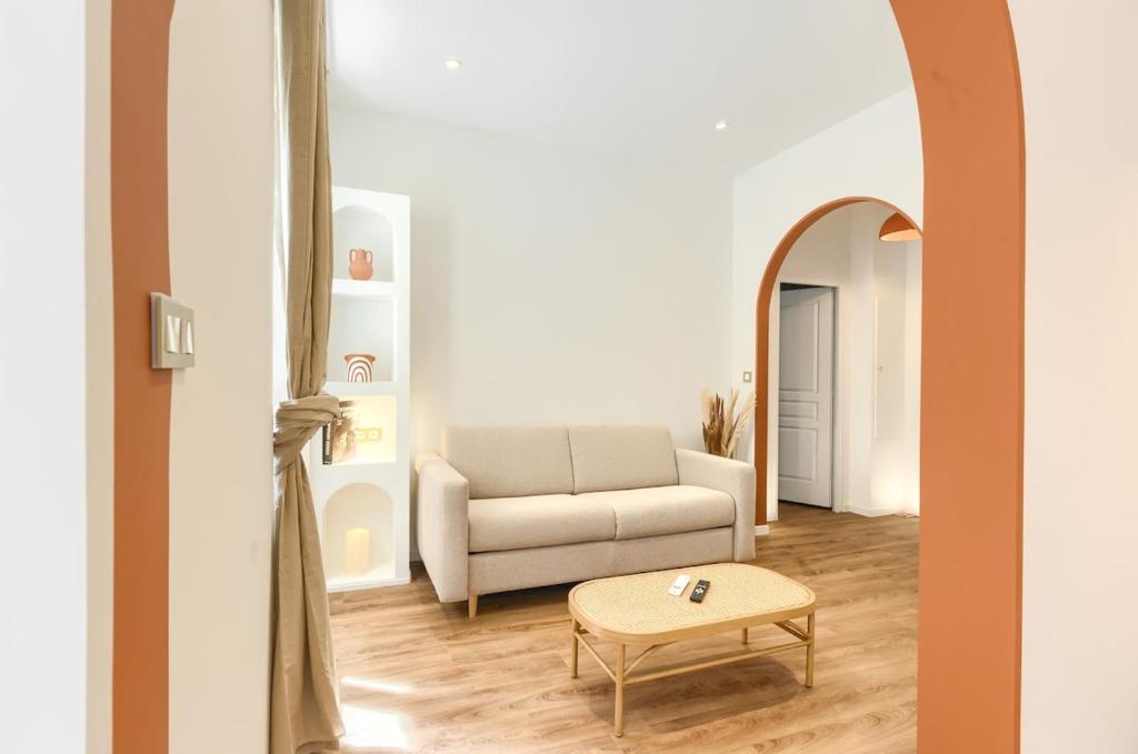un salon avec un canapé et une table dans l'établissement Appartement prestigieux à 5 minutes à pied de la gare et du palais de festival, à Cannes