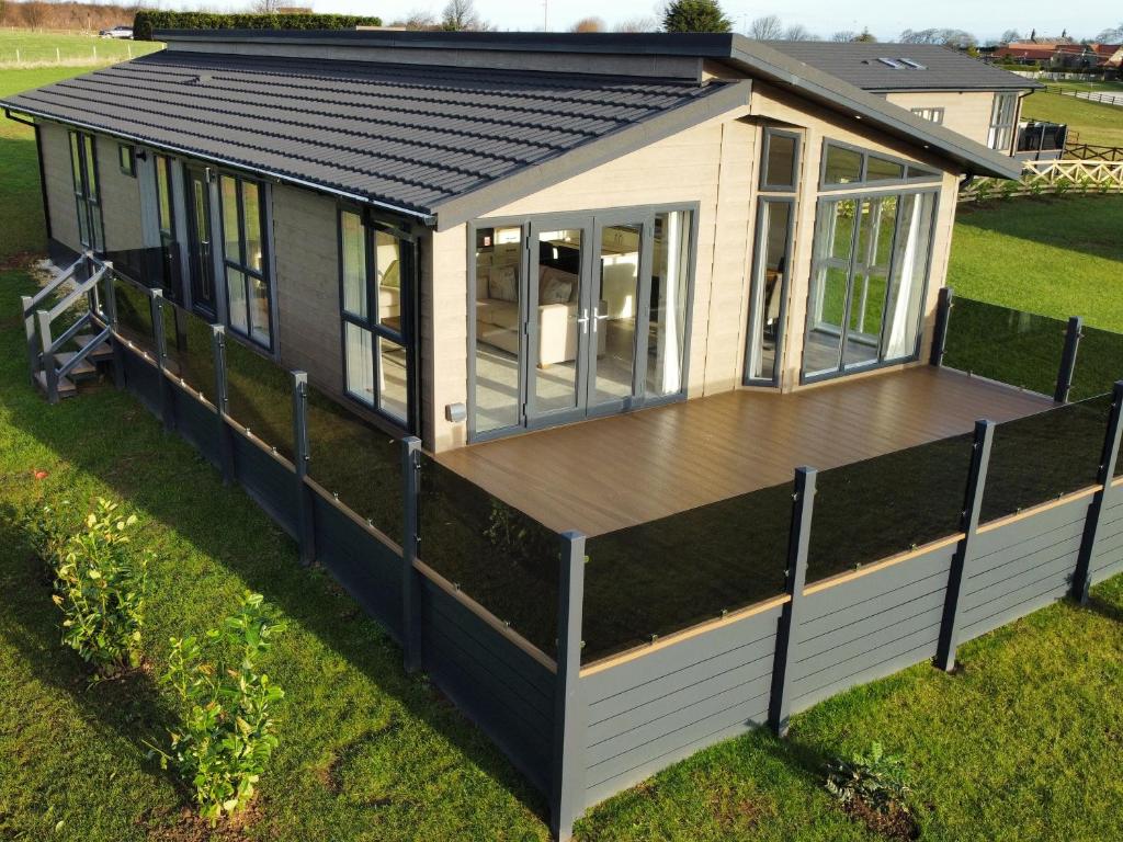 a house with a deck on the grass at Holly Lodge in Whitby