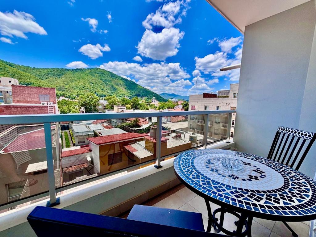 een balkon met een tafel en uitzicht op de stad bij C2 Apart Salta in Salta