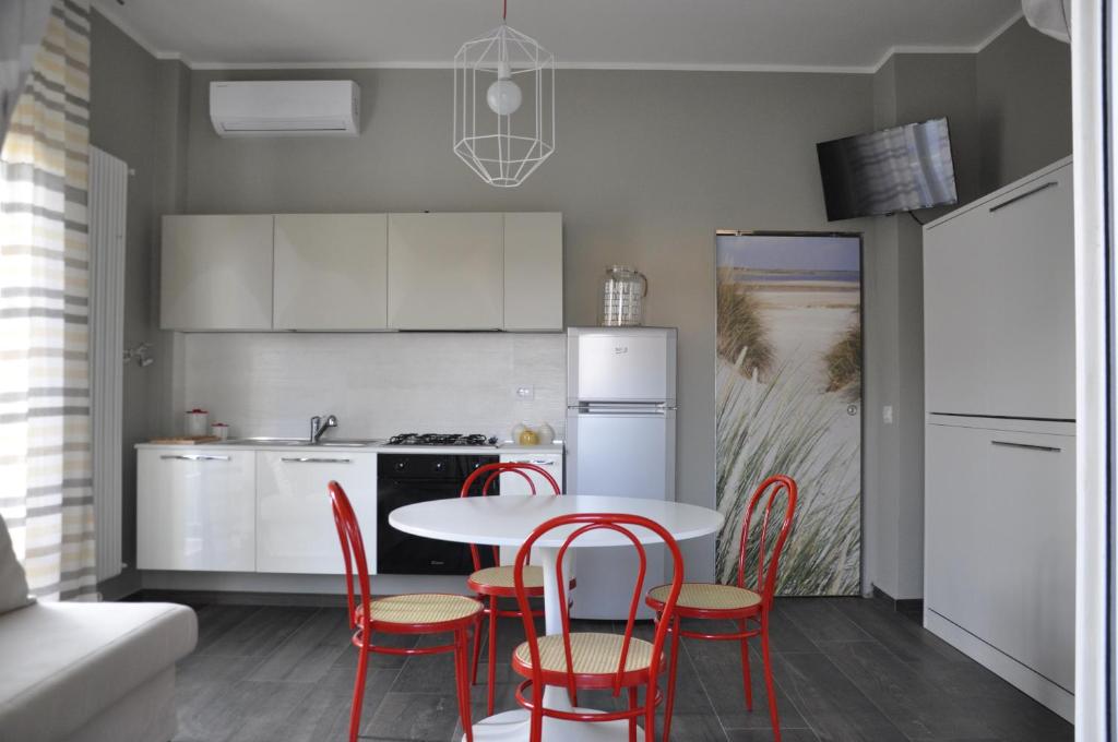 uma cozinha com uma mesa e cadeiras e um frigorífico em Casa Marzi em Pesaro