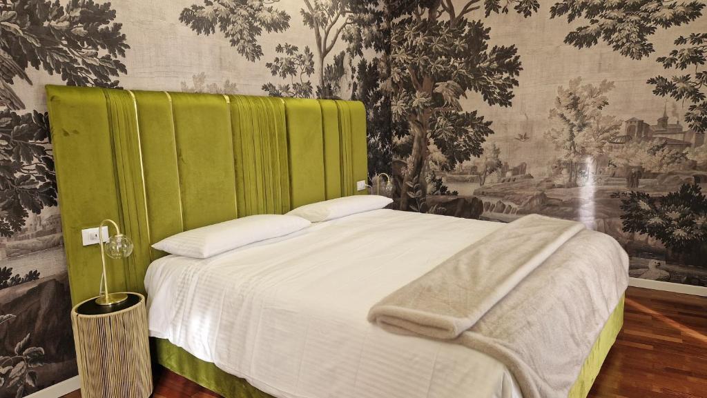 Una cama con cabecero verde en un dormitorio. en Orto del Re - Luxury Stay, en Catania