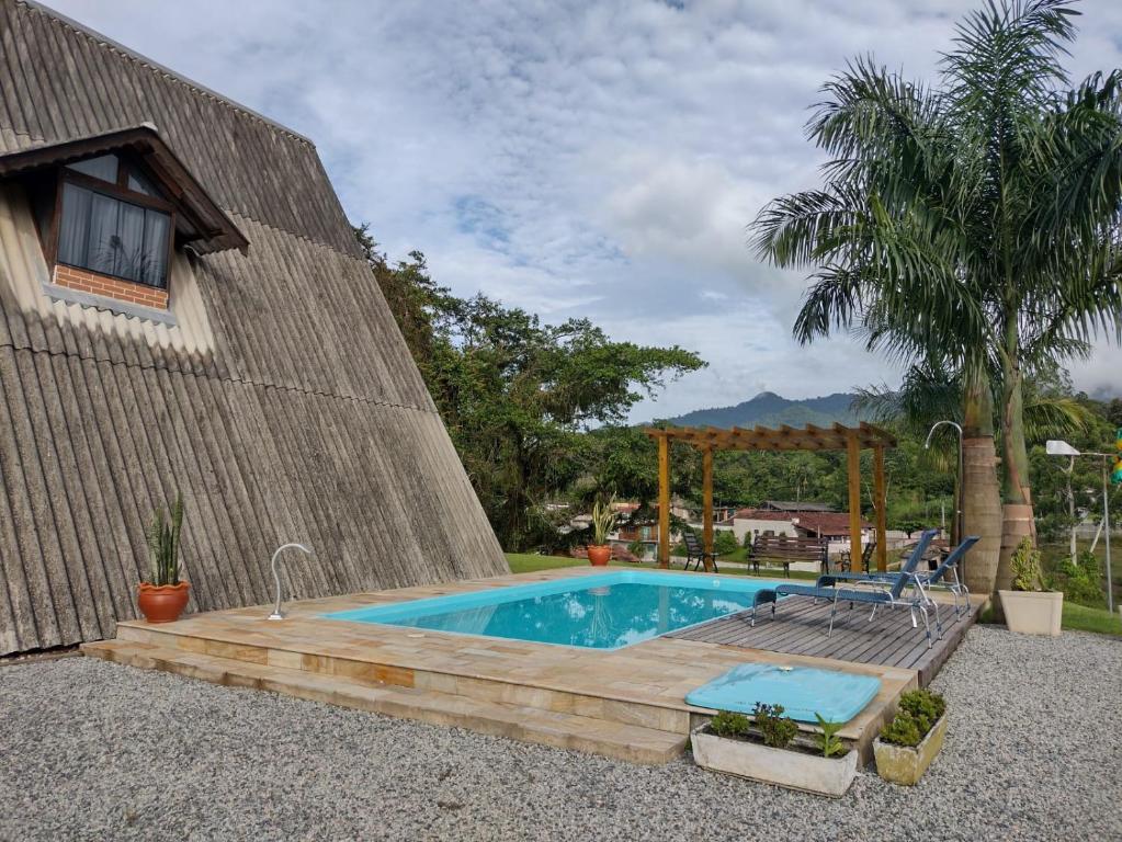 een zwembad met een houten terras naast een huis bij Chalé Bem-Estar in Massaranduba