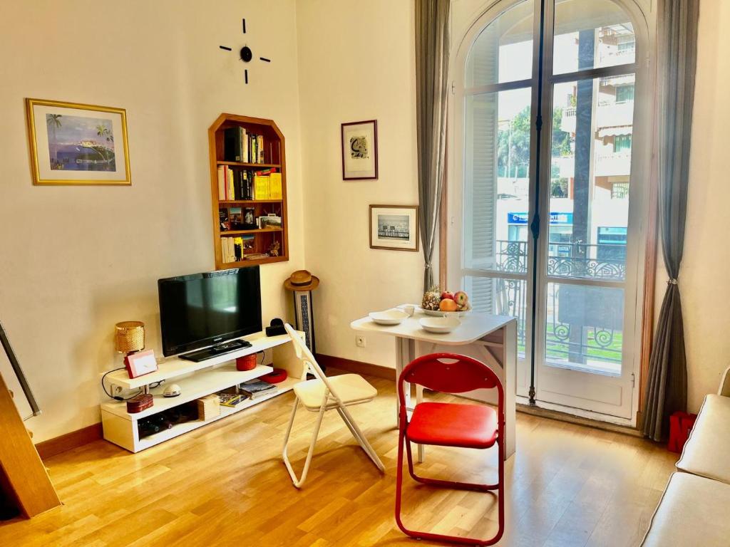 un salon avec un bureau et une télévision dans l'établissement Palais Monty YourHostHelper, à Nice