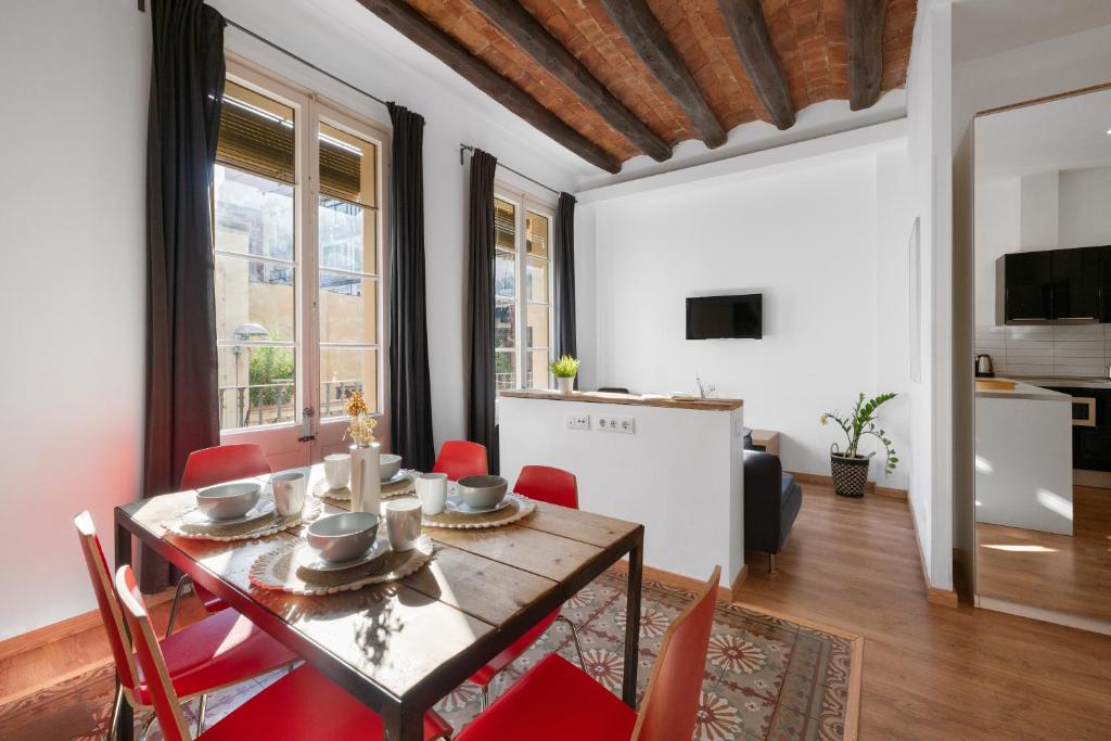 Un comedor con una mesa y sillas rojas. en AB Gran de Gràcia, en Barcelona