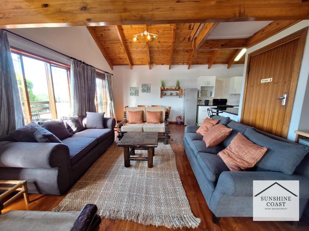un soggiorno con divani e un tavolo di PA Sands Beach House Kowie River 9 Sleeper Pool a Port Alfred