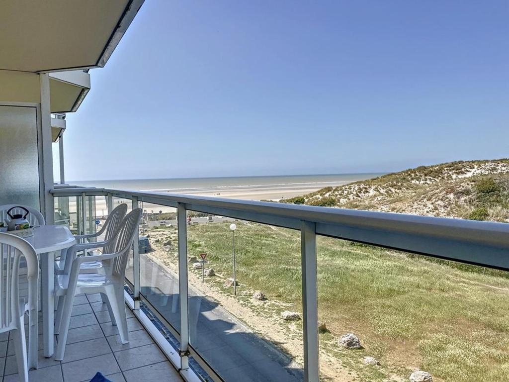 Un balcón con mesa y sillas y el mar. en Appartement 1 Chambre + Cabine avec Vue sur Mer & Dunes, 3ème Étage avec Ascenseur - FR-1-236-73, en Stella-Plage