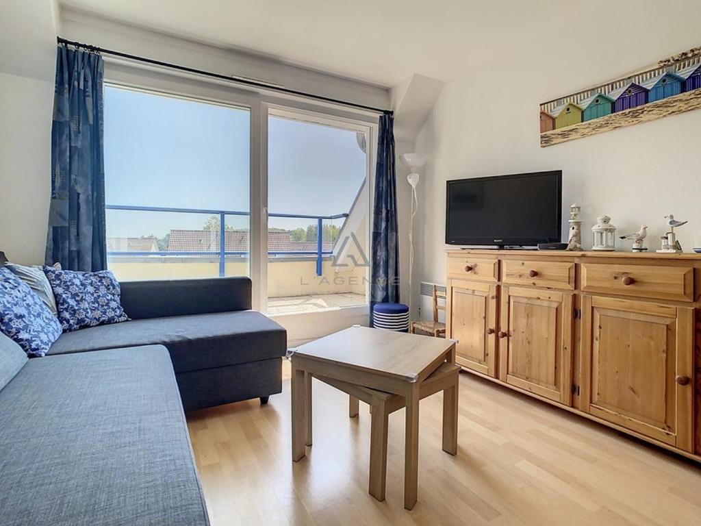a living room with a couch and a tv at Appartement 2 chambres proche mer et centre, parking inclus - FR-1-236-66 in Stella-Plage