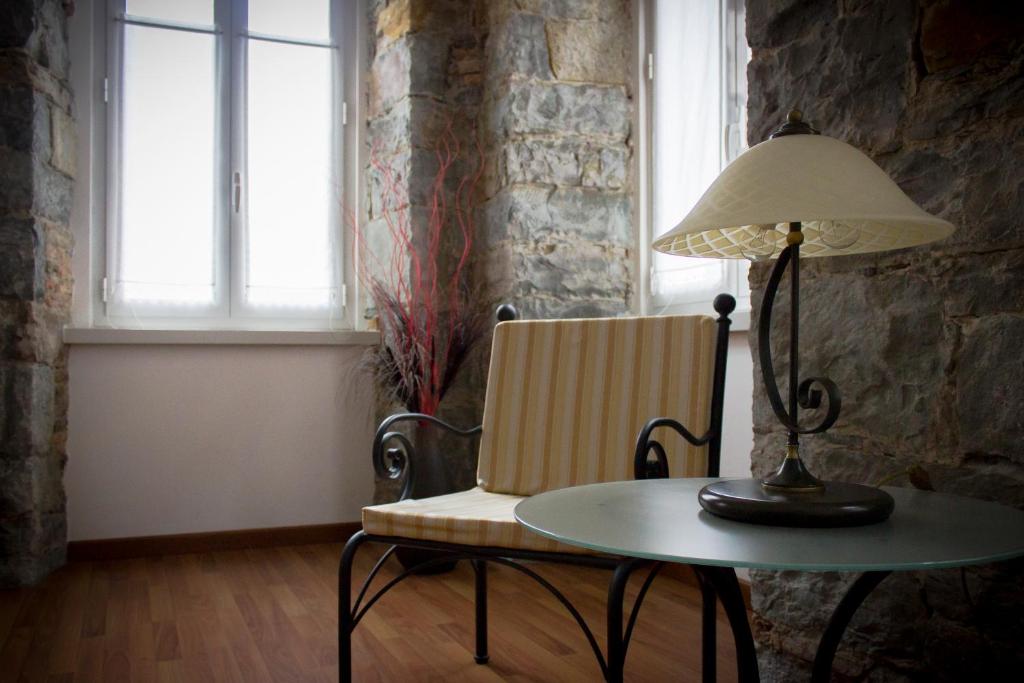 una mesa con una lámpara y una silla y una mesa con una lámpara en Residence Theresia- Tailor Made Stay, en Trieste
