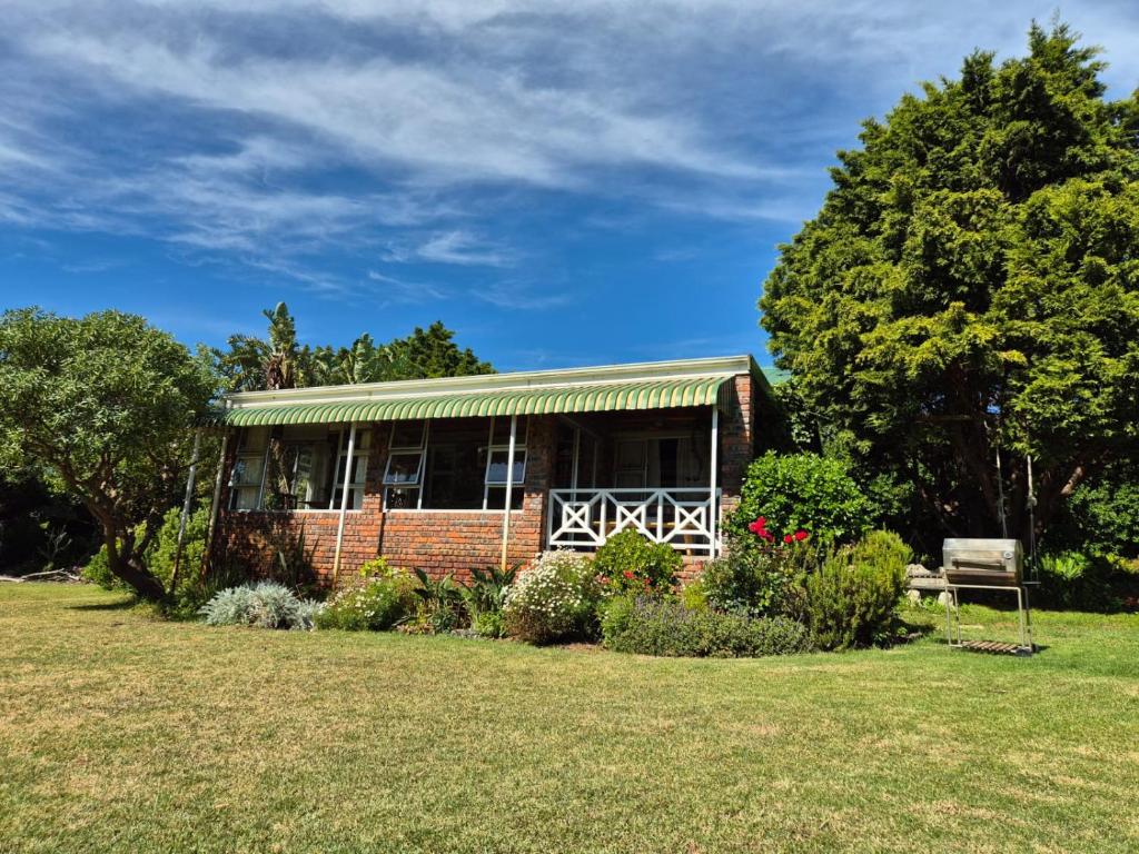 a brick house with a bench in a yard at Sea Cottage in Noordhoek