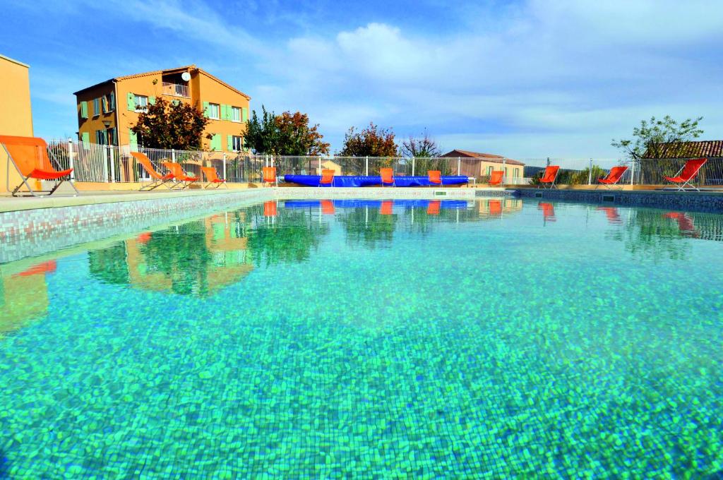 a large pool of blue water with chairs in it at VTF Le Domaine du Grand Luberon in Céreste