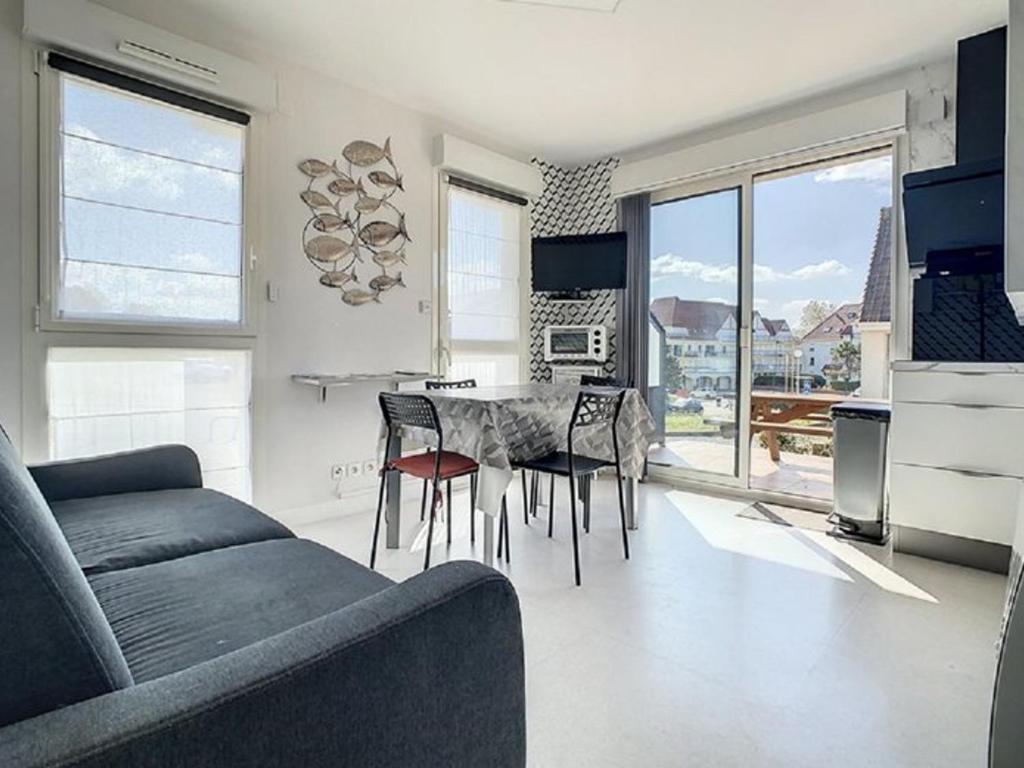 a living room with a couch and a table and chairs at Charmant T2 à Stella-plage, proche mer, tout confort - FR-1-236-147 in Cucq