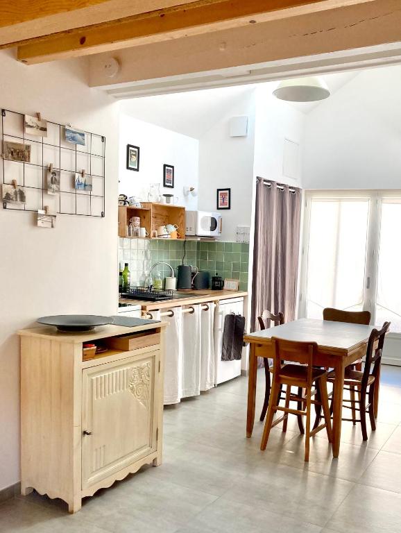 - une cuisine avec une table, une table et des chaises dans l'établissement La Petite Maison, à Guérande